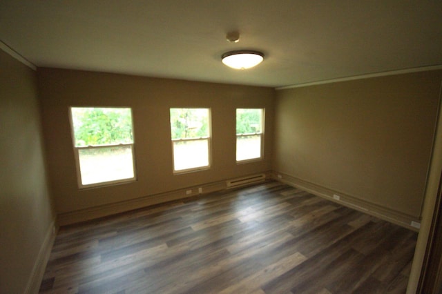 spare room with dark hardwood / wood-style flooring, ornamental molding, and baseboard heating