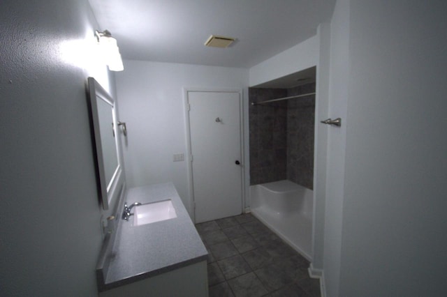 bathroom featuring vanity and tiled shower / bath