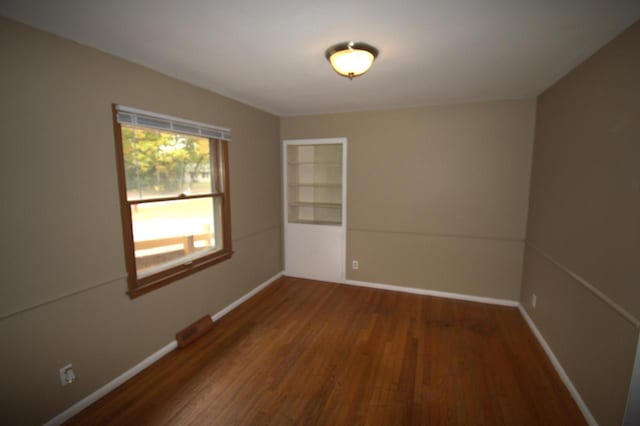 unfurnished room featuring dark wood-type flooring