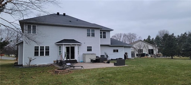 rear view of property featuring a lawn, a patio, and an outdoor fire pit