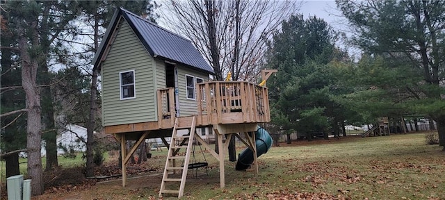 rear view of property featuring a yard and a playground