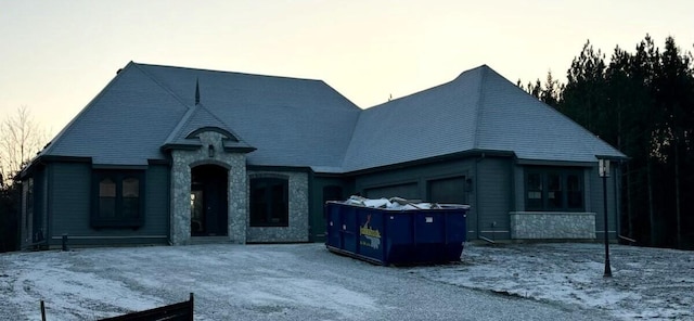 view of front of property with a garage and stone siding