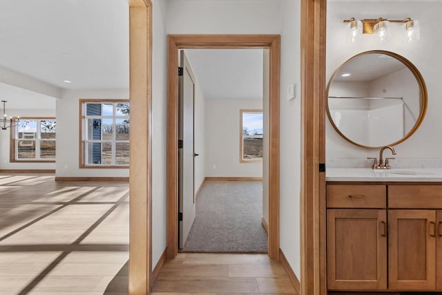 interior space featuring sink, light hardwood / wood-style flooring, plenty of natural light, and an inviting chandelier