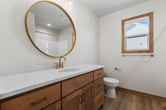 bathroom with vanity, toilet, wood-type flooring, and walk in shower