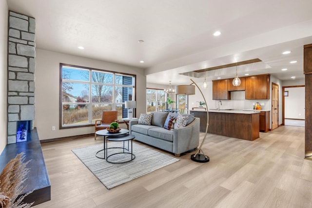 living room featuring sink, a chandelier, and light wood-type flooring