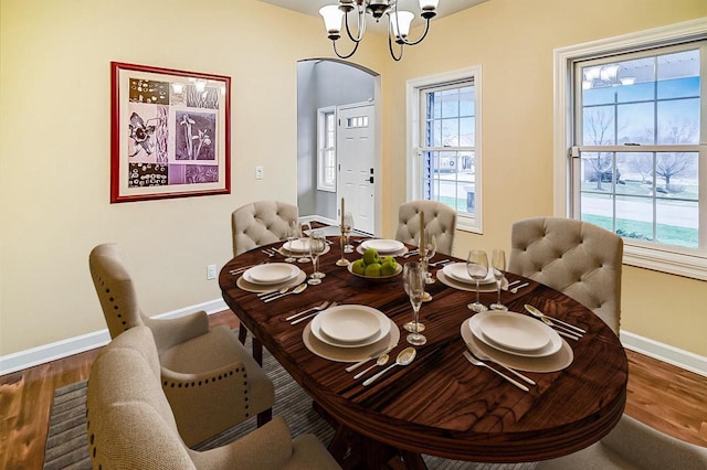 dining area with hardwood / wood-style flooring and a chandelier