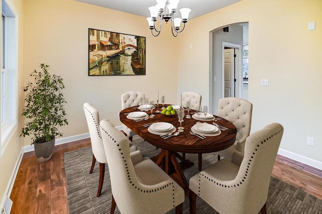 dining space with a notable chandelier and dark hardwood / wood-style flooring