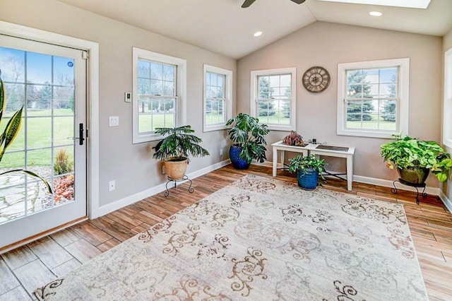 sunroom / solarium featuring ceiling fan, lofted ceiling with skylight, and a wealth of natural light