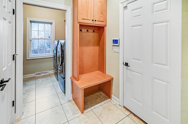 mudroom featuring washing machine and dryer and light tile patterned floors