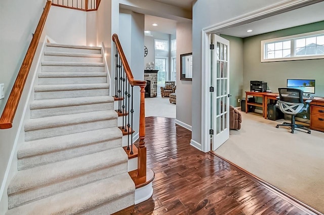 staircase featuring hardwood / wood-style floors and a fireplace