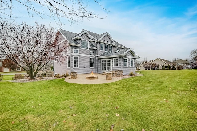 rear view of property featuring a yard, a patio area, and an outdoor fire pit