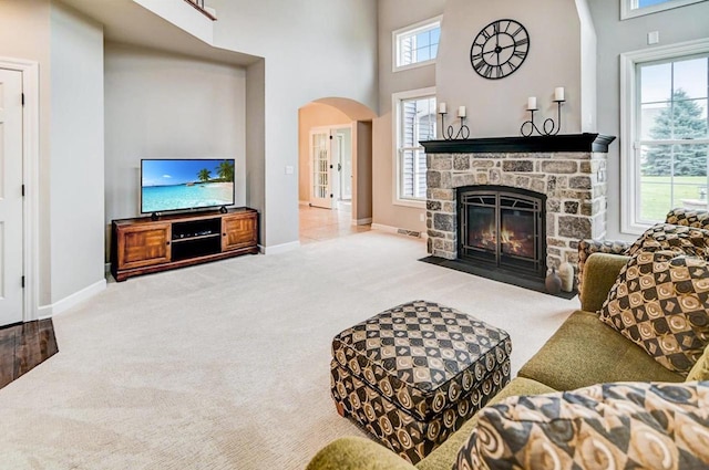 living room featuring carpet floors, a fireplace, and a high ceiling