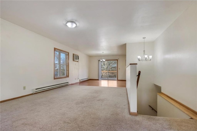 empty room featuring carpet, an inviting chandelier, an AC wall unit, and a baseboard heating unit