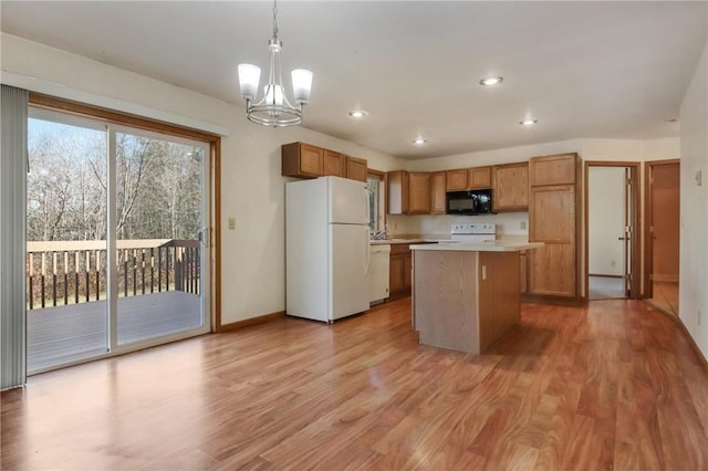 kitchen with a chandelier, pendant lighting, white appliances, a kitchen island, and light wood-type flooring