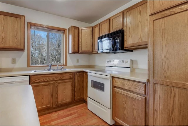 kitchen with white appliances, light hardwood / wood-style floors, and sink