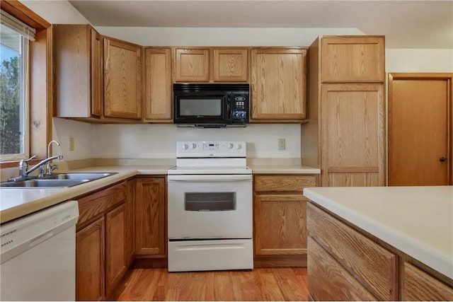 kitchen with white appliances, light hardwood / wood-style flooring, and sink