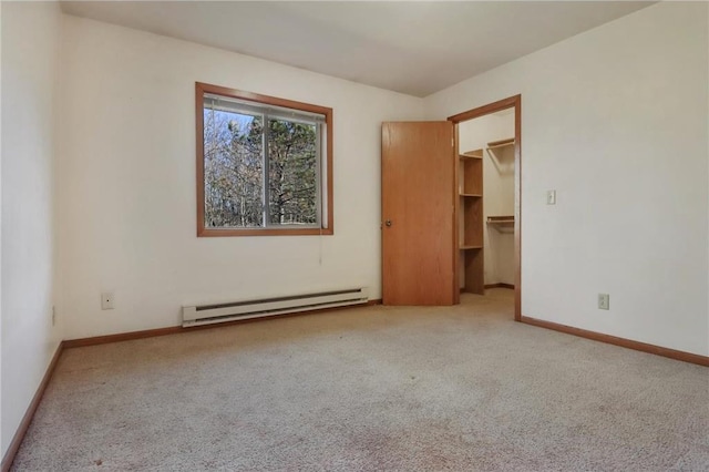 carpeted empty room with a baseboard heating unit