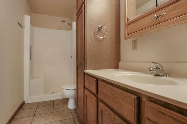 bathroom with a shower, vanity, tile patterned floors, and toilet