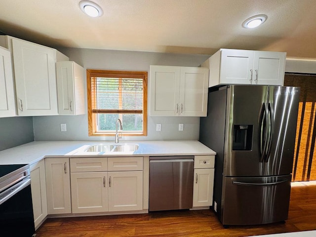 kitchen featuring dark hardwood / wood-style flooring, white cabinetry, sink, and stainless steel appliances