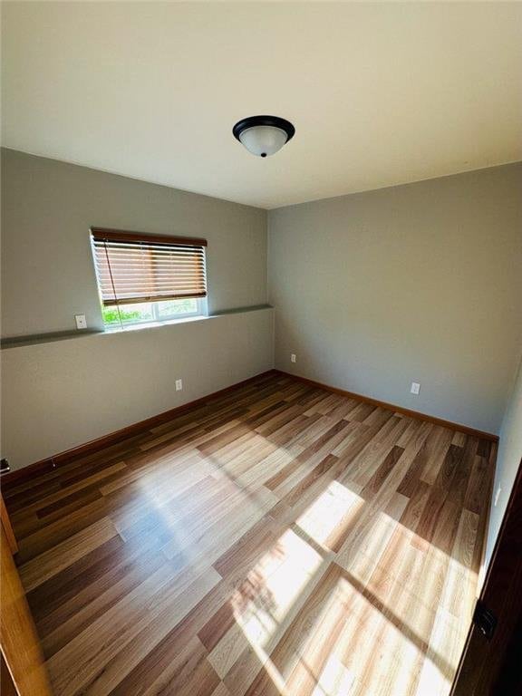 unfurnished room with hardwood / wood-style flooring