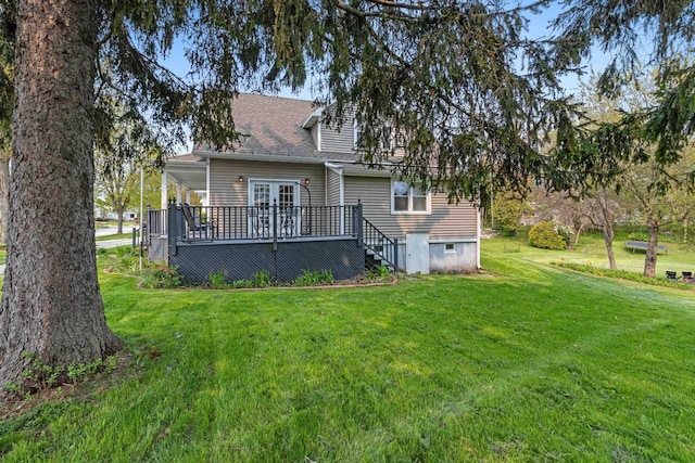 back of property featuring a deck and a yard