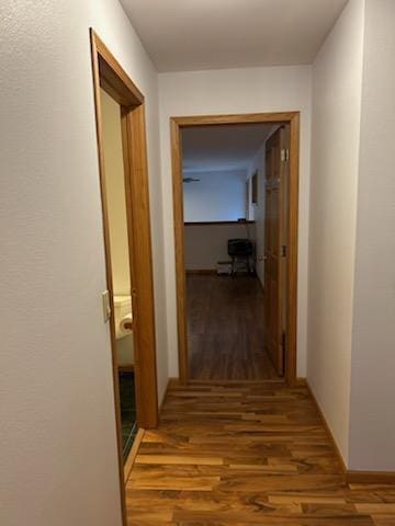 corridor with hardwood / wood-style flooring