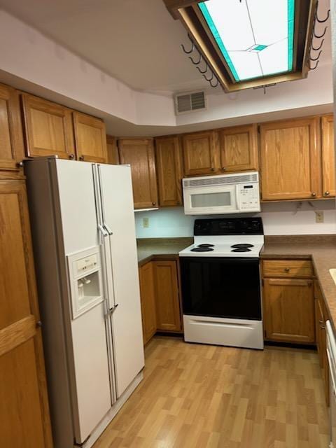 kitchen featuring white appliances and light hardwood / wood-style floors