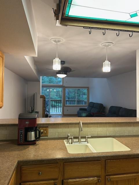 kitchen featuring backsplash, hanging light fixtures, and sink