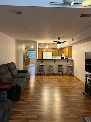 living room featuring ceiling fan and dark hardwood / wood-style flooring