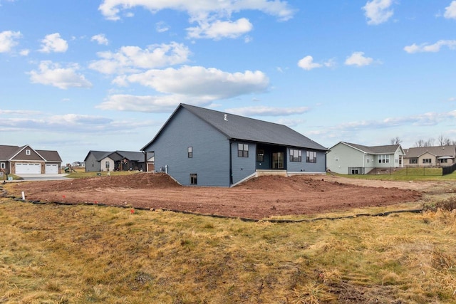 rear view of house with a garage and a yard