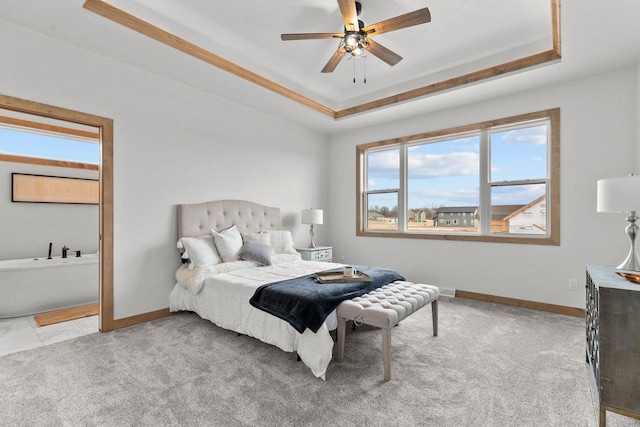 bedroom featuring ceiling fan, light colored carpet, and a tray ceiling