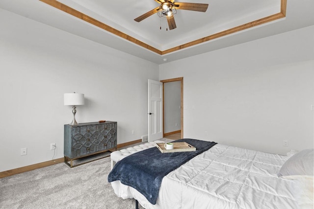 bedroom featuring a tray ceiling, ceiling fan, and carpet flooring