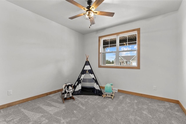 playroom with ceiling fan and carpet