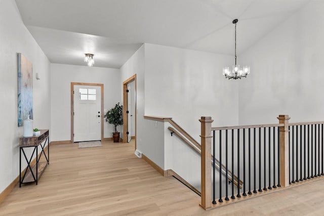 foyer with a notable chandelier and light hardwood / wood-style flooring