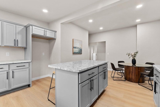 kitchen featuring gray cabinets, a kitchen island, and light wood-type flooring