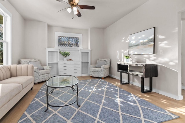 living room featuring wood-type flooring and ceiling fan