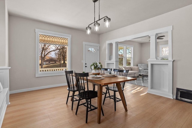 dining room featuring decorative columns, ceiling fan, and light hardwood / wood-style flooring