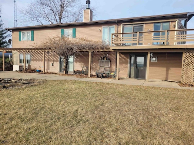 back of house featuring a pergola, a patio area, a lawn, and a balcony