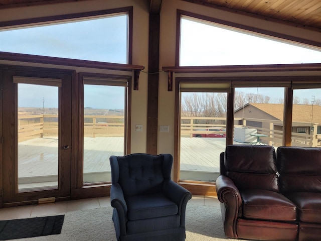 living room with lofted ceiling with beams, light tile patterned floors, a wealth of natural light, and wooden ceiling