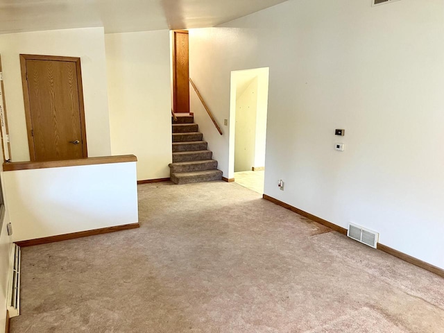 carpeted empty room featuring vaulted ceiling