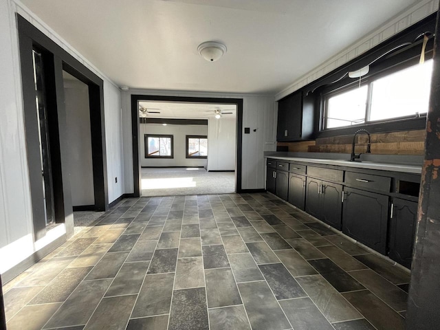 kitchen featuring ceiling fan, crown molding, and wood walls