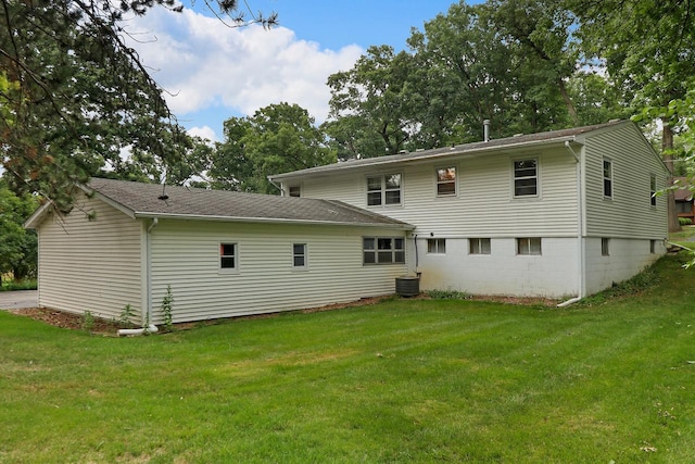 back of house with a yard and central air condition unit