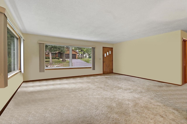 unfurnished living room featuring a textured ceiling and light colored carpet