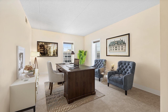 home office featuring light carpet, a textured ceiling, and baseboards