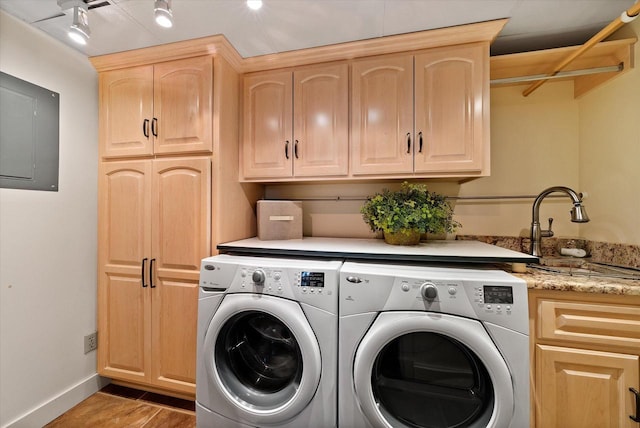 laundry room with washer and clothes dryer, a sink, cabinet space, and baseboards