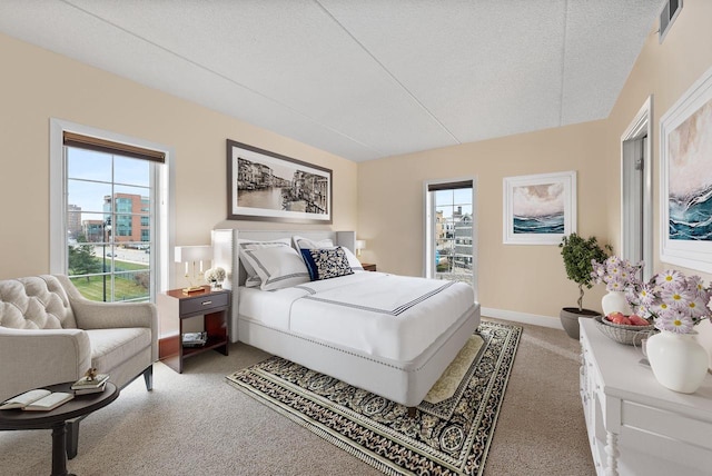 bedroom featuring a textured ceiling, carpet floors, visible vents, and baseboards