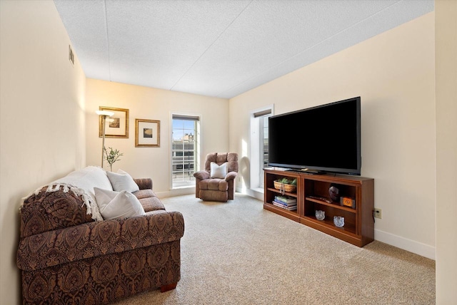 living room with carpet floors, baseboards, and a textured ceiling