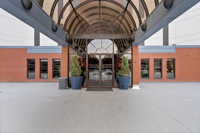 entrance to property featuring french doors and brick siding