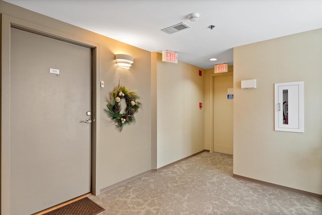 interior space with visible vents, baseboards, and light colored carpet