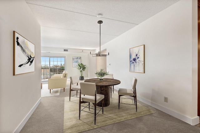 carpeted dining area with visible vents, baseboards, and a textured ceiling